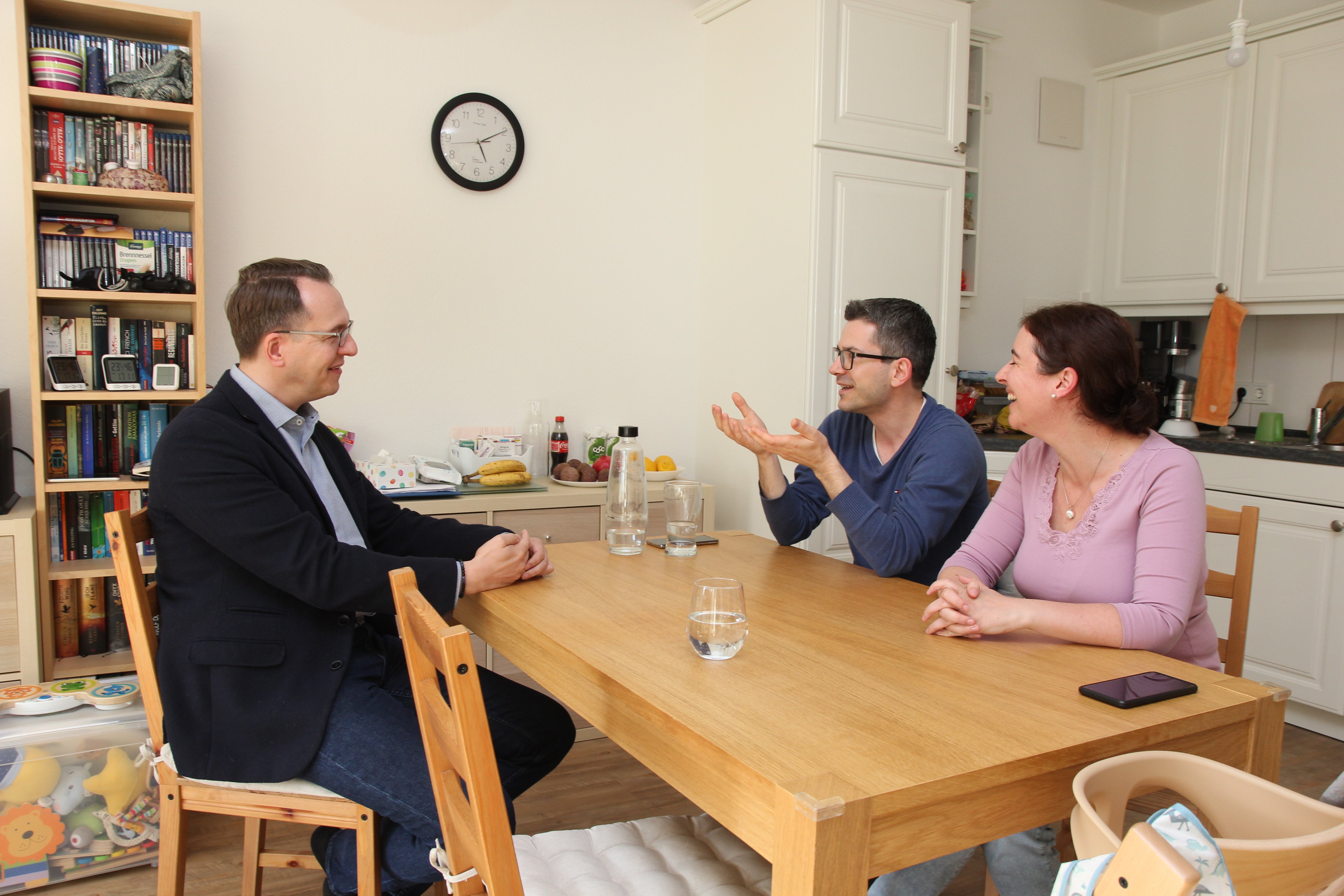 Dr. Sven Groth zusammen mit Familie Pavlov zu Hause am Tisch gegenüber