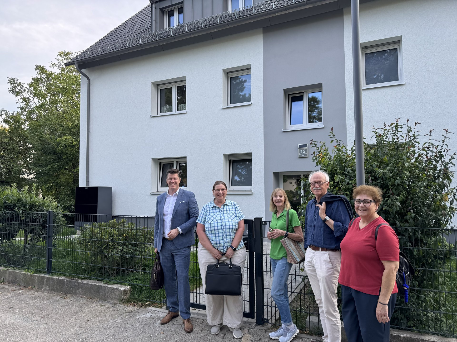 Der Wohnungsausschuss bei der Besichtigung vor dem modernisierten Haus