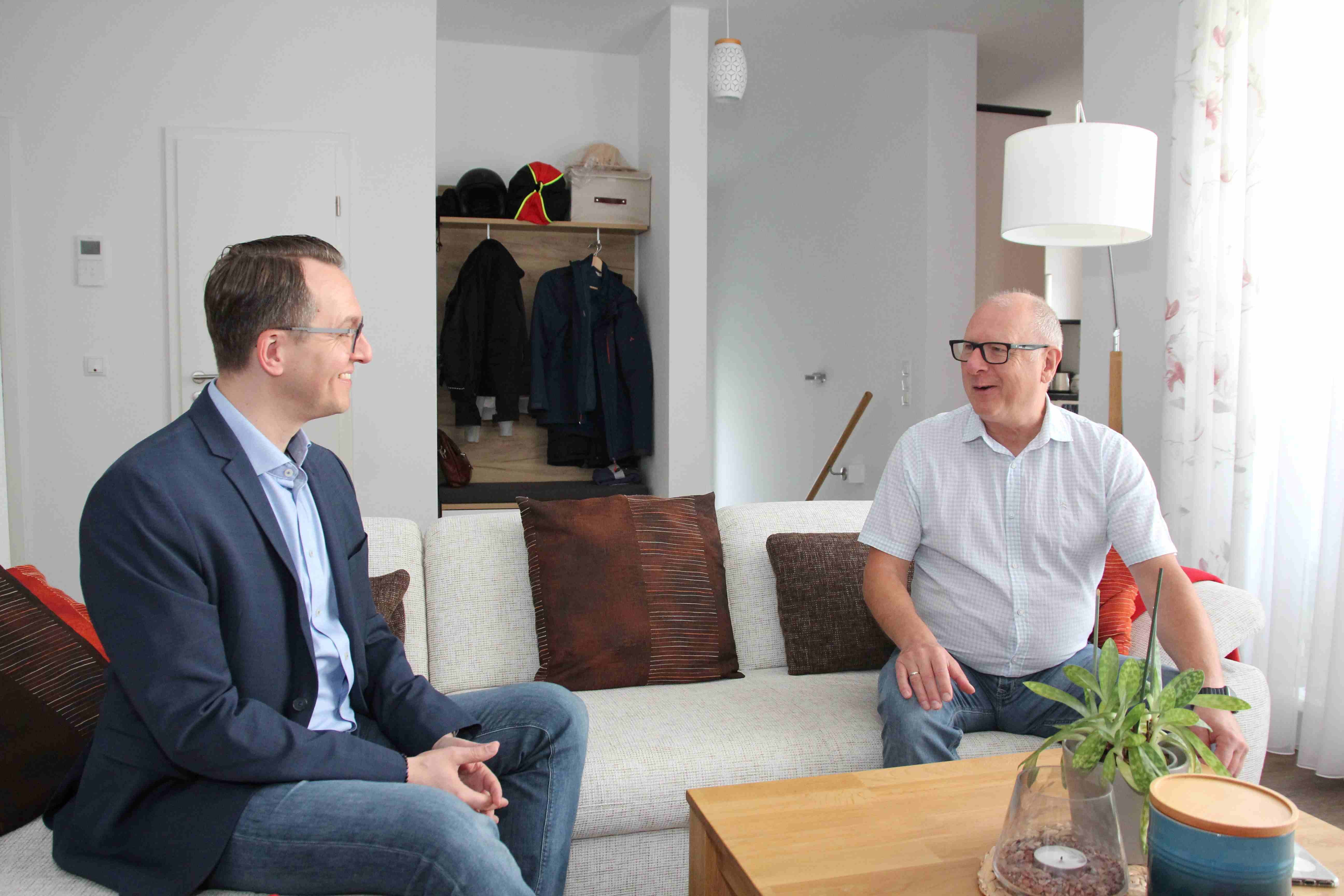 Dr. Sven Groth sitzt gegenüber von Jörg Hellmich zu Hause auf der Couch