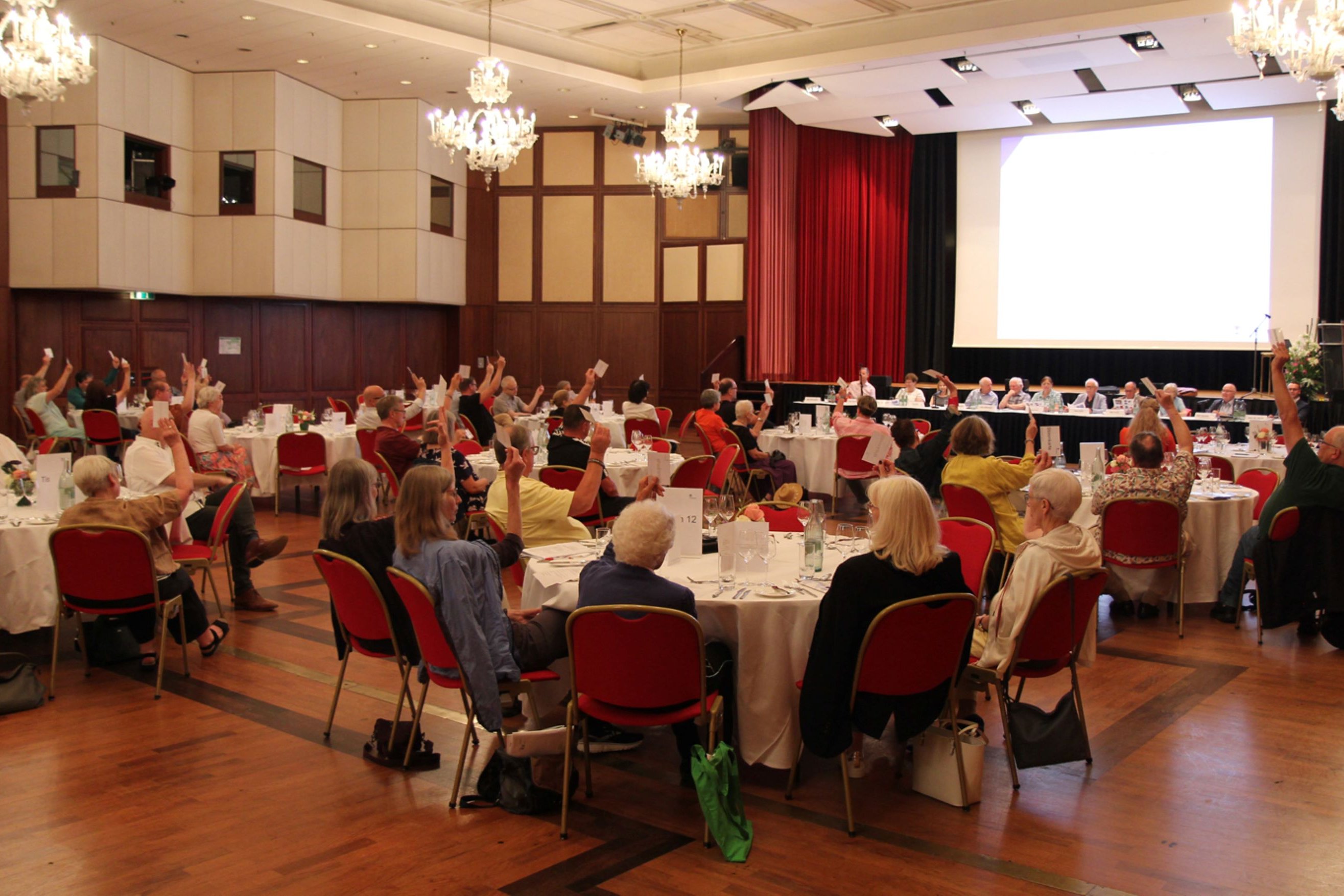 Saal mit Personen und Tischen